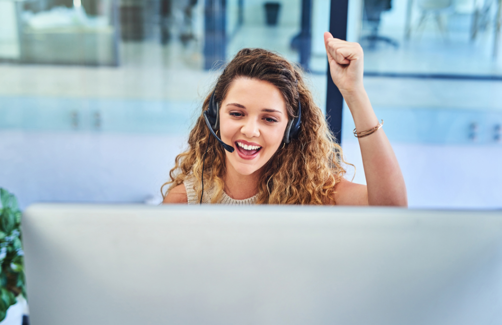 Smiling woman wearing a headphone with her fist in the air