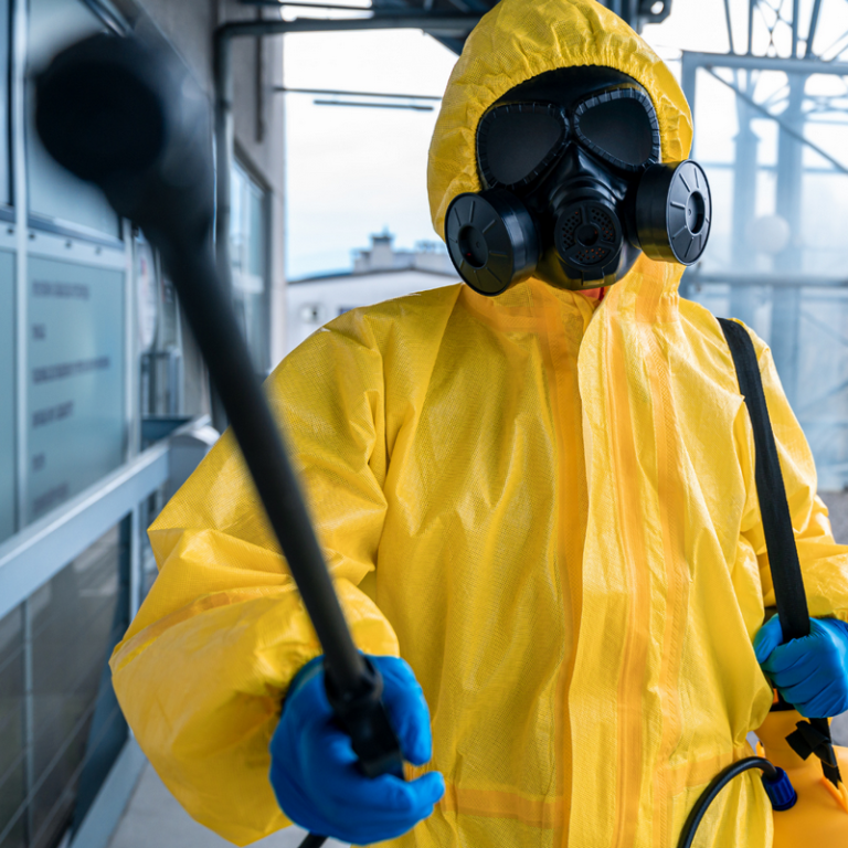 Cleaning personnel in full body suit with a power cleaning tool